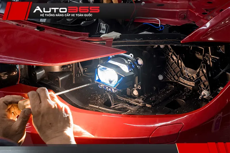 Kỹ thuật viên Auto365 cố định bi LED vào cụm đèn pha trước khi dán keo