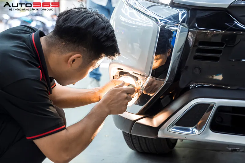 Kỹ thuật viên thao tác tại khu vực cụm đèn trước Mitsubishi Outlander 2022 