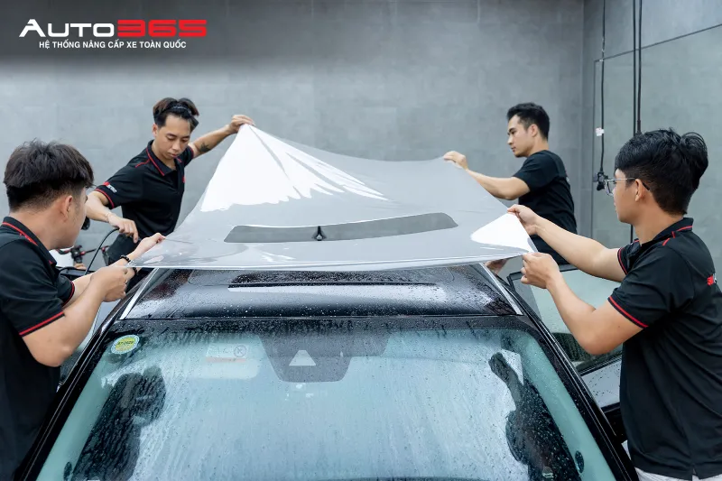 Kỹ thuật viên căn chỉnh và trải tấm PPF 3M 50 Gloss trên bề mặt Mazda CX-5 trong quá trình thi công