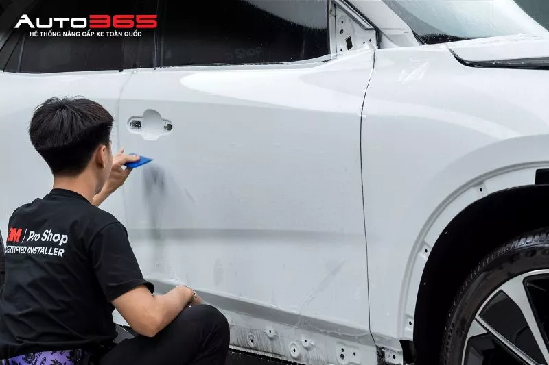 Kỹ thuật viên hoàn thiện PPF tại khu vực cửa trước bước kiểm tra và bàn giao