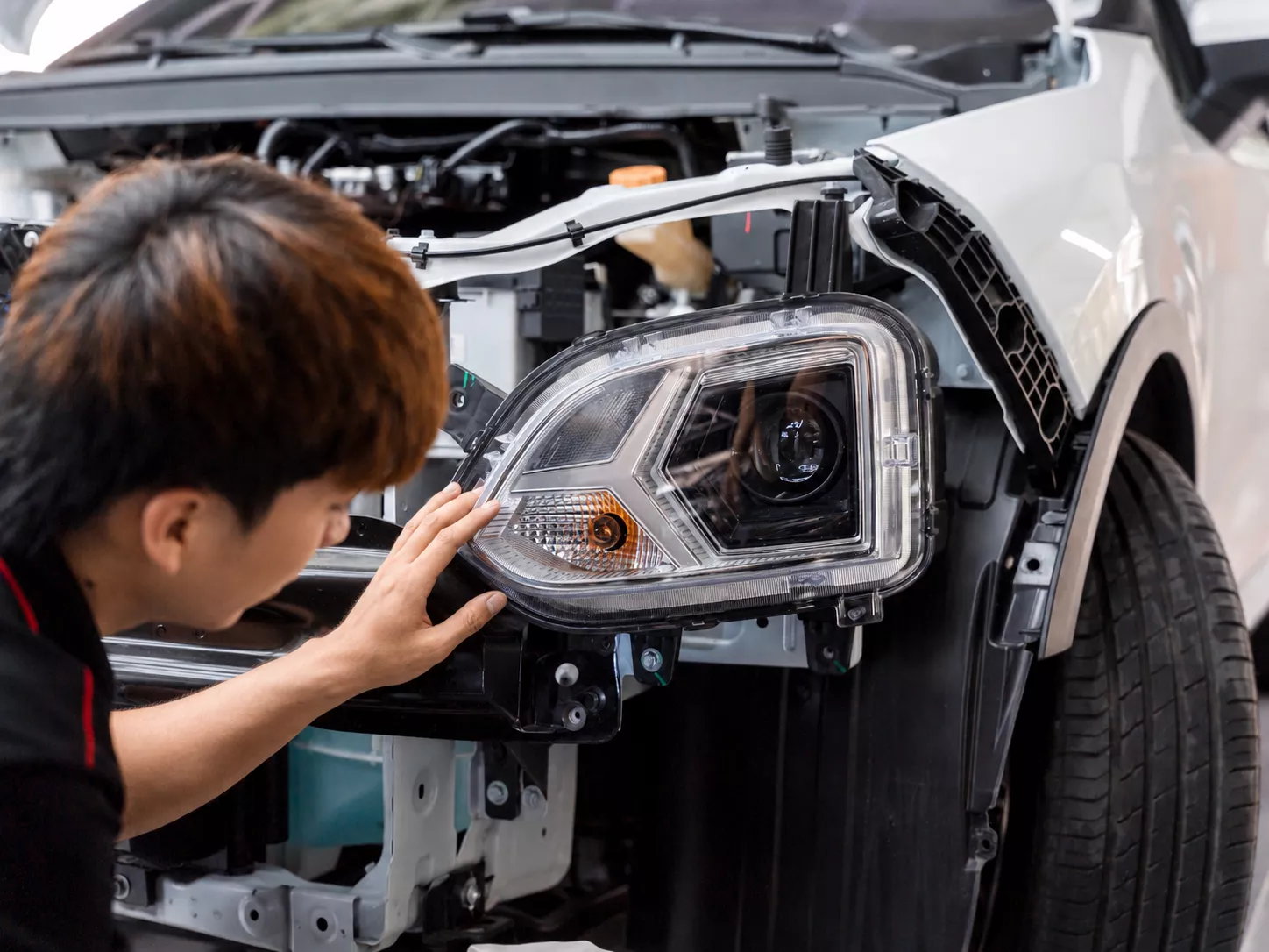 Kỹ thuật viên kiểm tra khi chăm sóc mặt kính đèn pha ô tô bị mờ, xước hoặc ố vàng