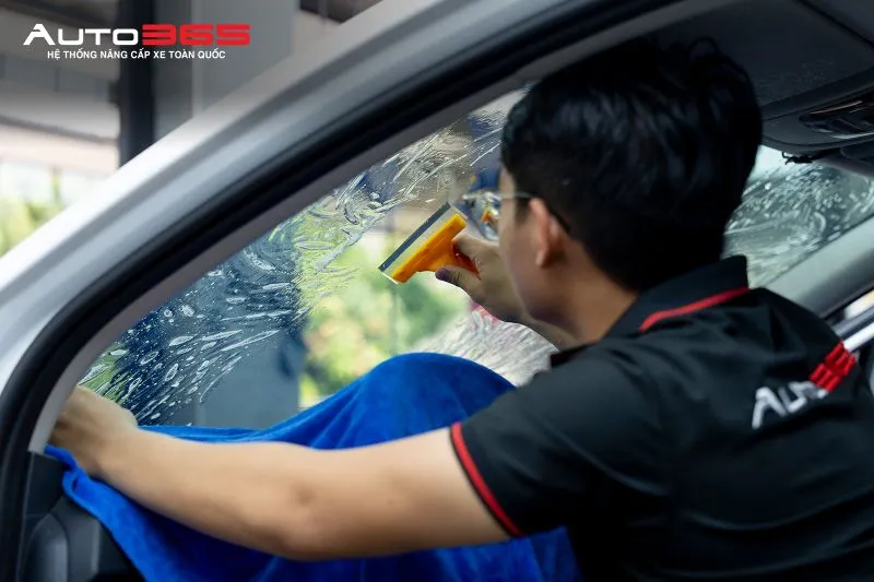 Kỹ thuật viên thi công phim cách nhiệt 3M Crystalline CR BLK 40 trên kính lái Kia Sportage tại Auto365.vn - Trụ Sở Chính