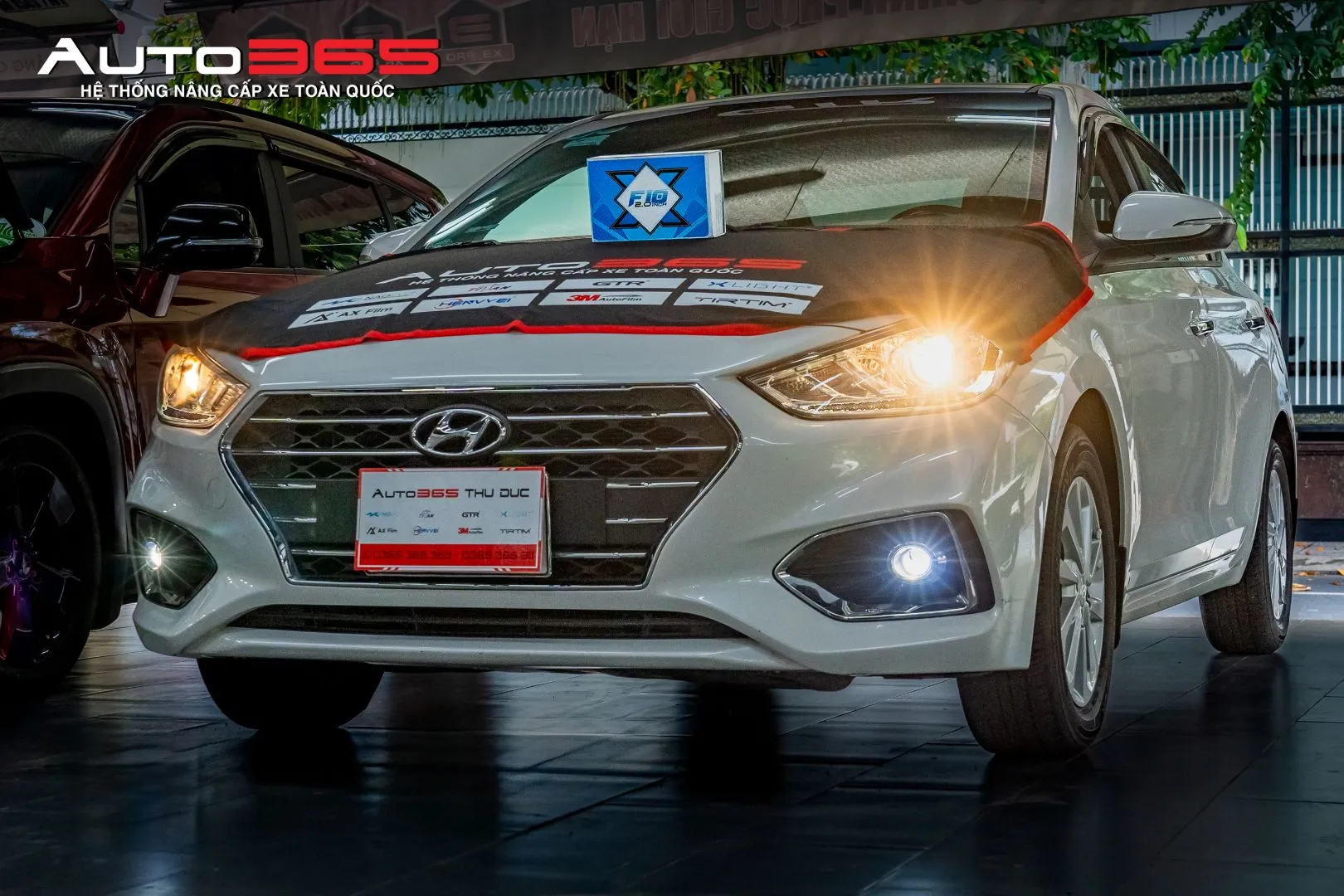 Hyundai Accent màu trắng cùng hộp X-Light F10 2.0 New trong bộ ảnh thực tế.