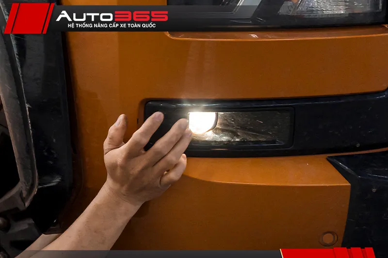 Kỹ thuật viên kiểm tra khu vực đèn gầm trên Mitsubishi Triton.