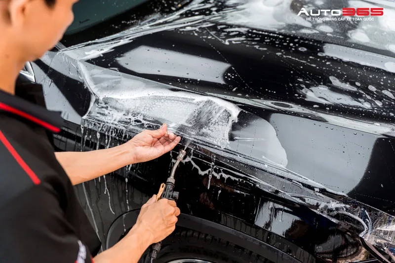 Kỹ thuật viên thi công PPF bảo vệ sơn trước đá văng trên nắp ca-pô ô tô